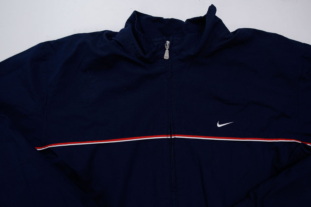 Navy Nike jacket featuring a white embroidered Swoosh logo and a red chest stripe, full view