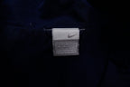 Navy Nike jacket featuring a white embroidered Swoosh logo and a red chest stripe, size label