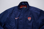 Nike track jacket in navy blue featuring an embroidered US Soccer crest, full view