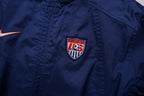 Nike track jacket in navy blue featuring an embroidered US Soccer crest, detail