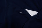 Nike zip-up track jacket in navy with red side panels and a small white swoosh logo, detail