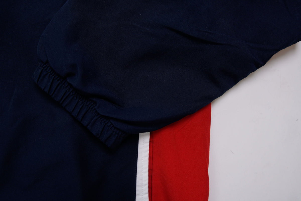 Nike zip-up track jacket in navy with red side panels and a small white swoosh logo, detail 2