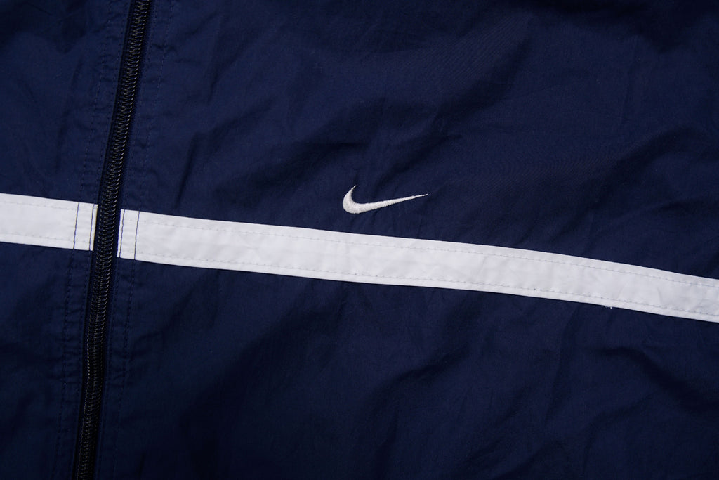 Navy Nike zip-up jacket with white contrast stripes across the chest and sleeves, detail