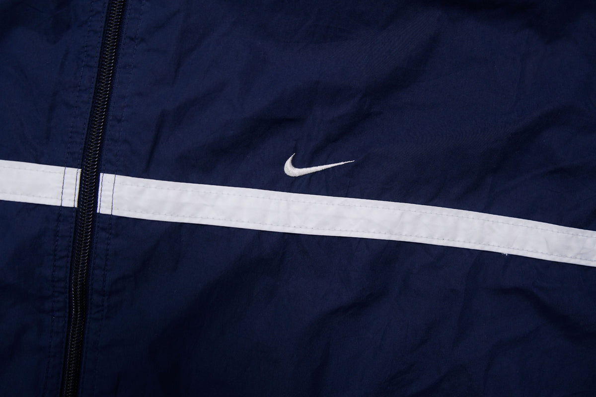 Navy Nike zip-up jacket with white contrast stripes across the chest and sleeves, detail