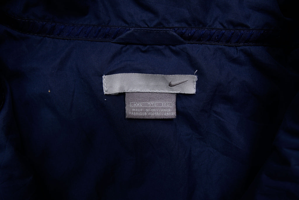 Navy Nike zip-up jacket with white contrast stripes across the chest and sleeves, size label