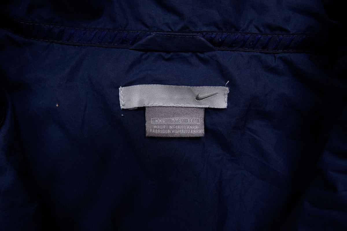 Navy Nike zip-up jacket with white contrast stripes across the chest and sleeves, size label