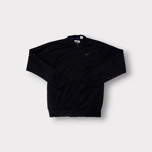Reebok track jacket in black with subtle chest logo and geometric stitching