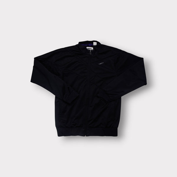 Reebok track jacket in black with subtle chest logo and geometric stitching